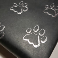 A close up to show the detail of the silver foil paw print.